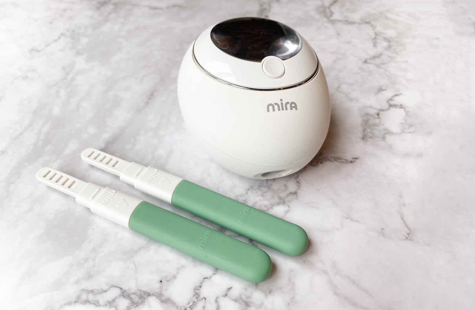 Picture of the Mira fertility monitor with two green confirm fertility wands — explanation of the Marquette Method of NFP's Mira Monitor Protocols